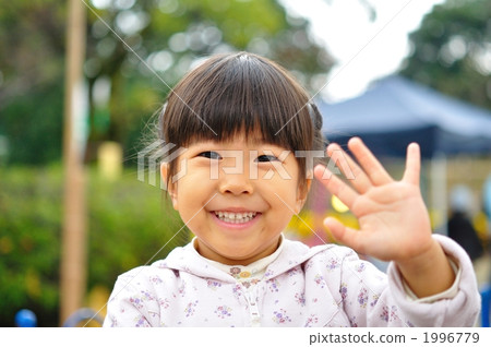 图库照片: 挥动有微笑的女孩一只手
