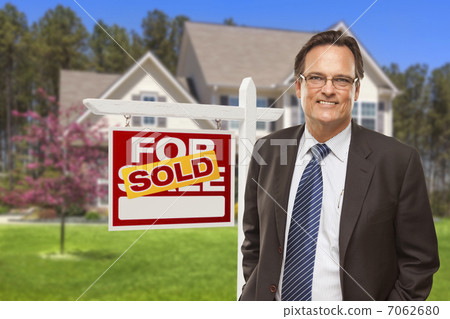 图库照片: male real estate agent in front of sold sign and house