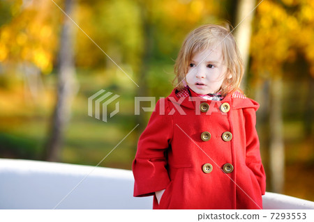 图库照片: little girl in bright red coat at autumn