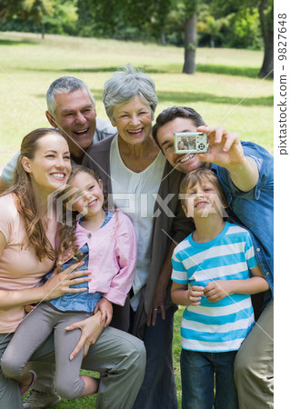 照片素材(图片): man taking picture of extended family at park