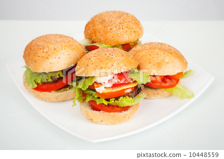 big homemade hamburgers lay on white plate. studio photo