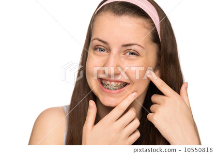 图库照片: smiling girl with braces squeezing pimple isolated