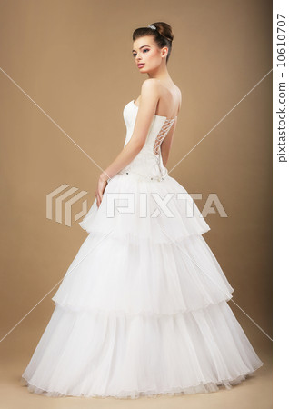 full length portrait of graceful bide in white wedding dress