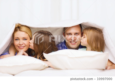 two little girls kissing their parents on cheek