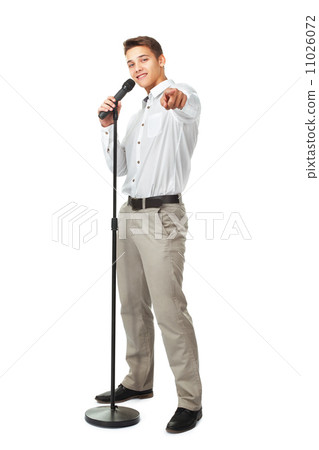 图库照片: young man singing into a microphone