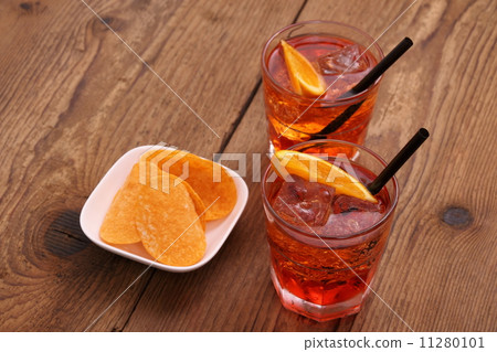 spritz aperitif - two orange cocktail, ice cubes, potato chips