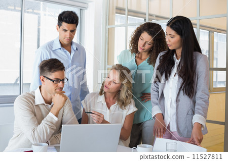 图库照片: casual business team having a meeting using laptop