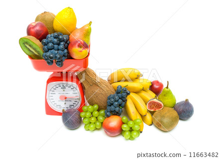 图库照片: healthy food - fresh fruit and kitchen scale on white