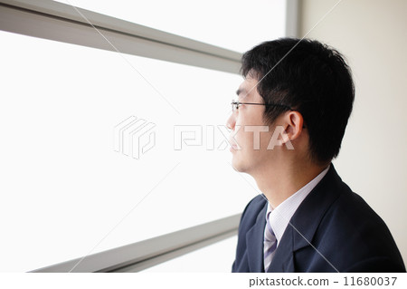 图库照片: business man look through window