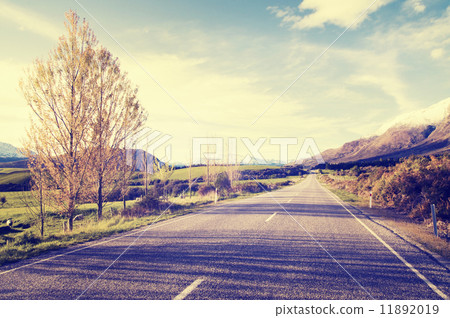 图库照片: autumn themed country road with mountain range as a
