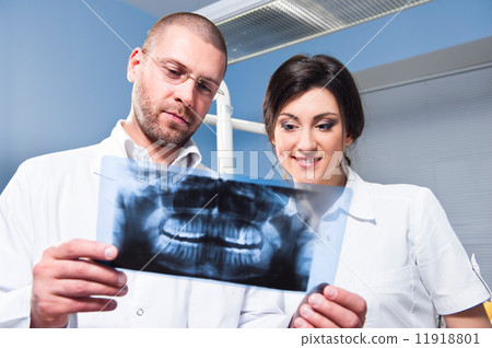 dentist and assistant checking x-ray at dental clinic