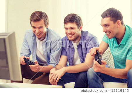 图库照片 smiling friends playing video games at home