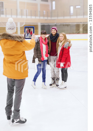 图库照片: happy friends taking photo on skating rink