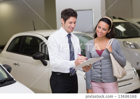 图库照片: salesperson showing clipboard to sign to customer