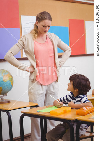图库照片 angry teacher looking pupil with hands on hips