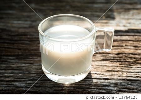 图库照片: fresh glass of milk on old wood background