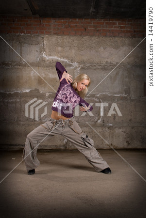 图库照片: beautiful hip hop girl dancing over grey brick wall