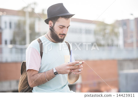 图库照片: young handsome hipster gay modern man using smartphone