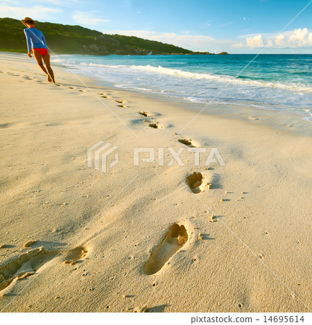 图库照片: woman at beautiful beach. focus on footprints.