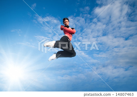 图库照片: sport woman jumping and fly over sky and sun