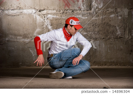 图库照片: hip hop boy dancing in modern style over grey brick