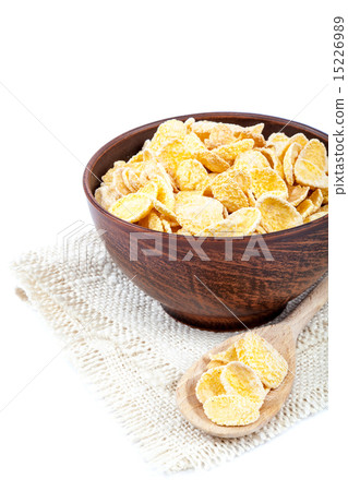图库照片: cornflakes in a wooden bowl on white background.