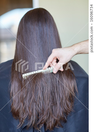 图库照片: hand with comb combing woman hair at salon