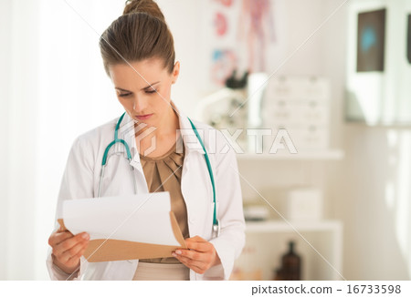 图库照片: medical doctor woman looking in clipboard