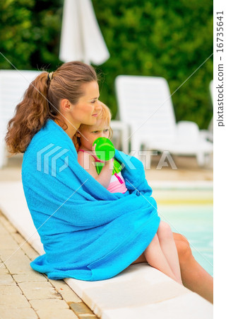 图库照片: mother and baby girl wrapped in towel sitting near