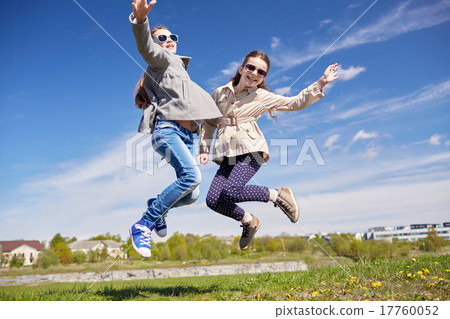 图库照片: happy little girls jumping high outdoors