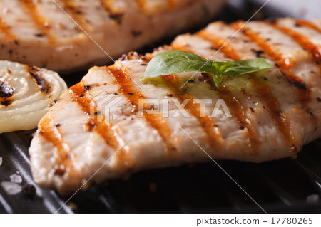 图库照片: chicken breast with onions and basil on grill