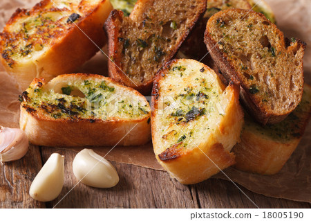 图库照片: toasted bread with herbs and garlic on paper