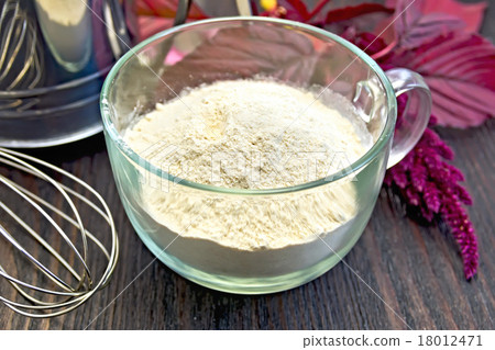 图库照片: flour amaranth in glass cup with sieve on board