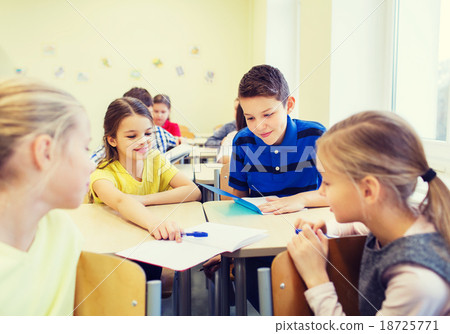 图库照片: group of school kids writing test in classroom