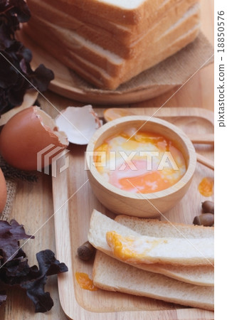 图库照片: soft-boiled egg with bread on wood background.