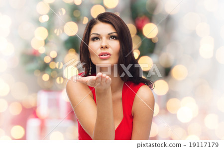 图库照片: woman sending blow kiss over christmas lights