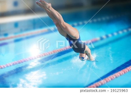 图库照片: female swimmer, that jumping into indoor swimming pool