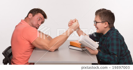 图库照片: young man and his son arm wrestling