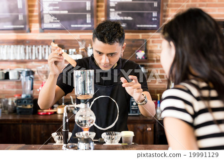 图库照片: woman watching barista preparing drip coffee