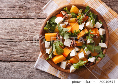 图库照片: salad with persimmon, nuts, arugula and cheese