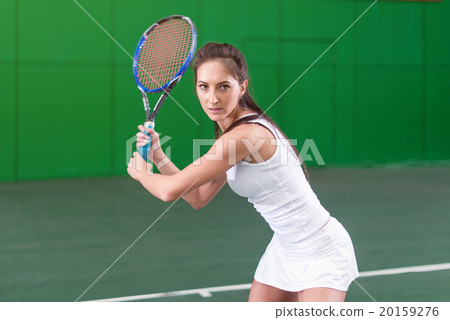 图库照片: portrait of a young woman playing tennis on court.