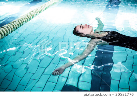 图库照片: relaxed woman floating in the swimming pool