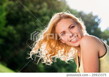 图库照片: blond woman, flipping curly hair. sunny summer