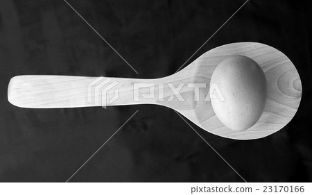 图库照片: egg on a wooden spoon, still life black and white