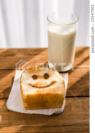 图库照片: happy toasted and a glass of milk on wooden