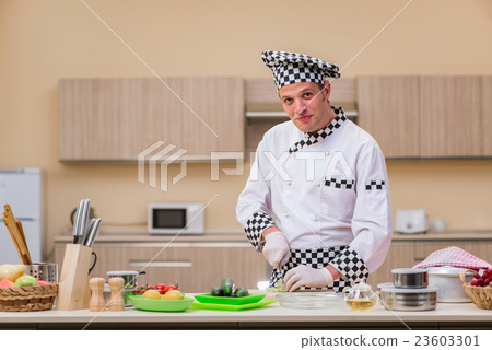 图库照片: male cook preparing food in the kitchen