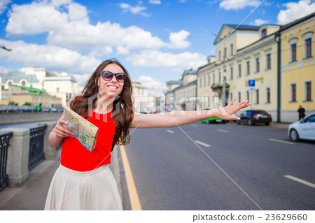 图库照片: young happy girl catch a taxi with city map in