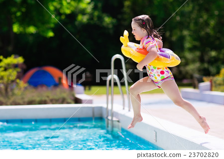 图库照片: little girl jumping into swimming pool