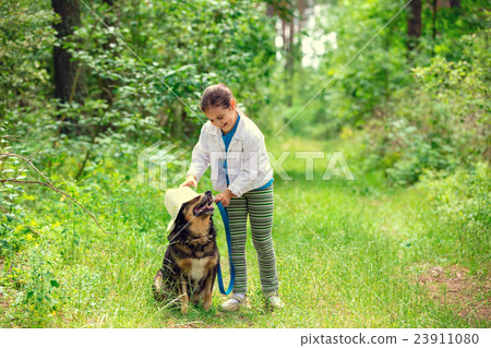 图库照片: happy little girl playing with dog in the forest