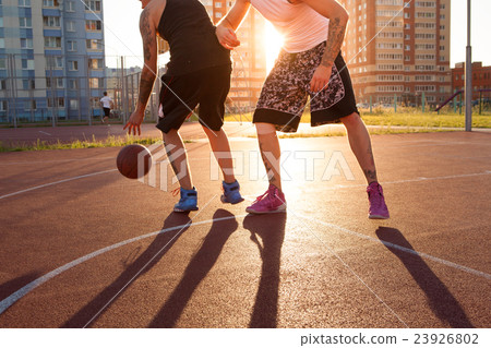 图库照片: two guy play basketball at district sports ground.